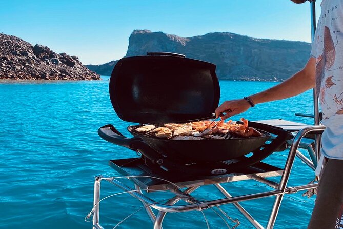Half-Day Exclusive Catamaran Cruise in Santorini with Meal and Open Bar - A wine-fueled cruise vibe, with drinks and music that set the tone