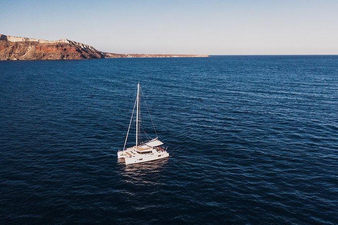 Romantic Sunset Catamaran Caldera Cruise incl. Meal & Drinks - Oia sunset from the sea: your best seat comes with wind prep