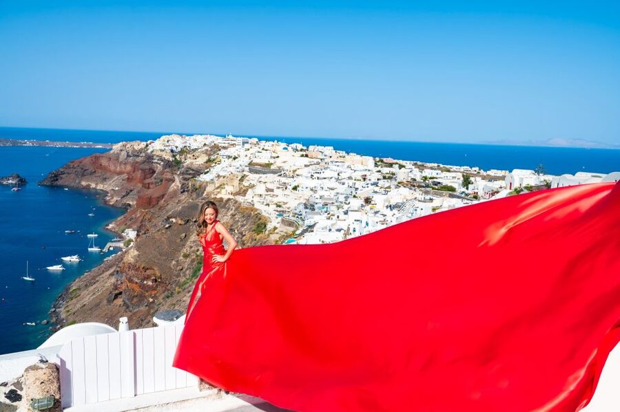 Santorini: Private Flying Dress Photoshoot with Pickup - Oia: classic blue domes and the caldera frame