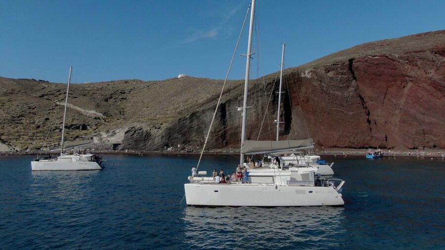 Santorini: Sunset Cruise with Greek Dinner and Transfer - Sailing the caldera: from viewpoint cruising to beach swimming
