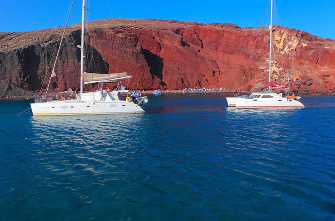 Shared Catamaran Romantic Sunset Cruise from Santorini via Volcano - Aspri Paralia: white cliffs, gray volcanic sand, and time to look closely